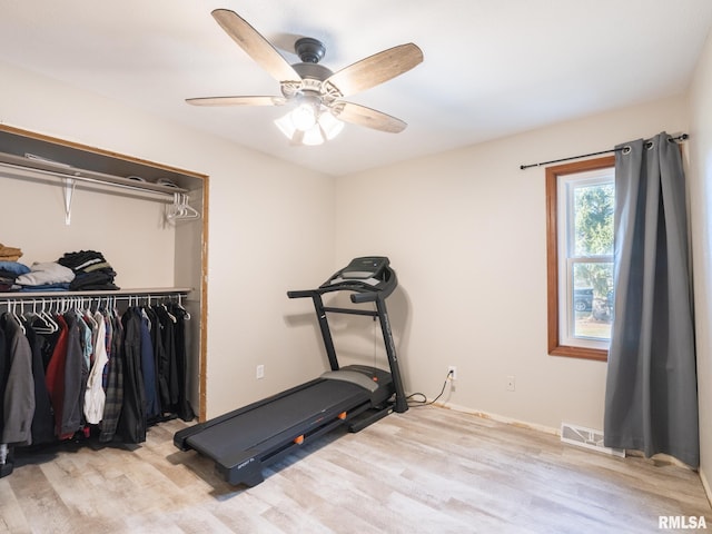 exercise room featuring ceiling fan and light wood-type flooring