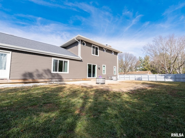 back of house with cooling unit, a patio, and a lawn