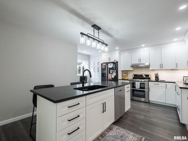 kitchen featuring appliances with stainless steel finishes, sink, a kitchen island with sink, and white cabinets