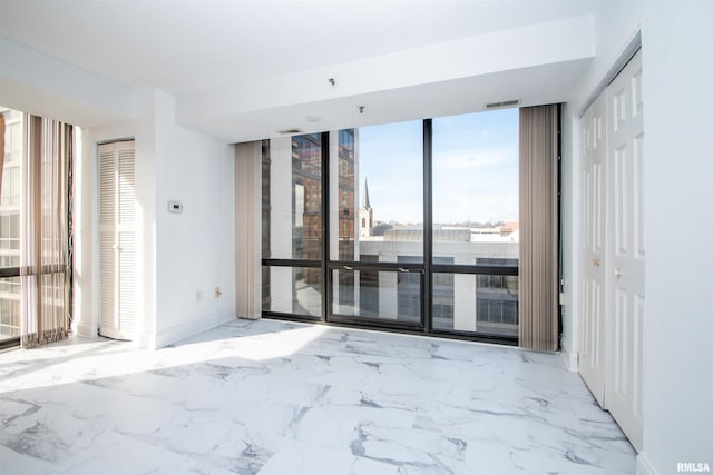 spare room with floor to ceiling windows