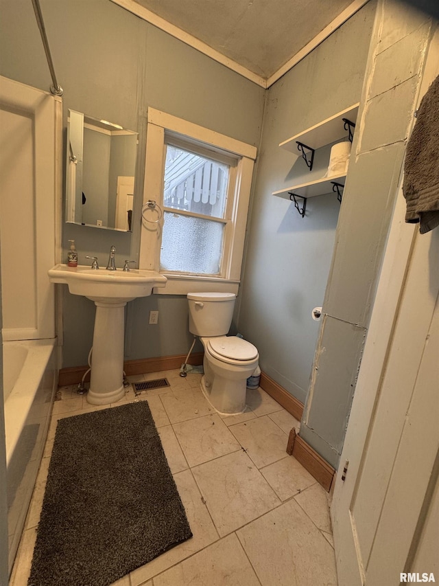 bathroom featuring a tub to relax in and toilet