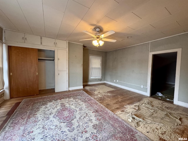 unfurnished bedroom featuring ceiling fan, hardwood / wood-style floors, and a closet