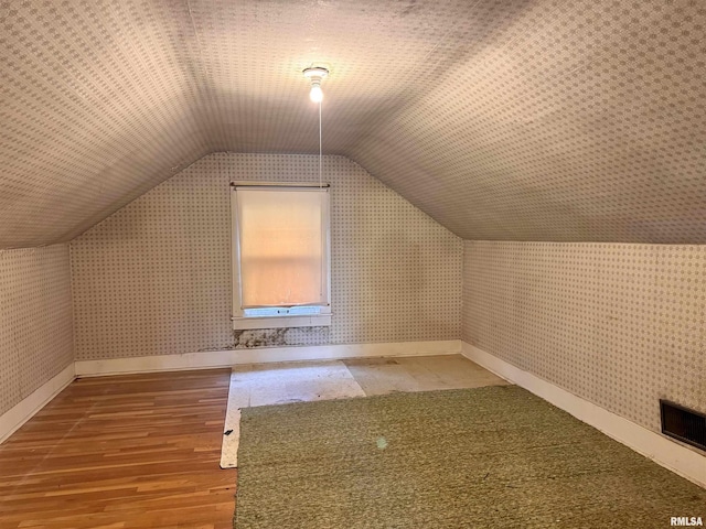 bonus room with lofted ceiling and wood-type flooring