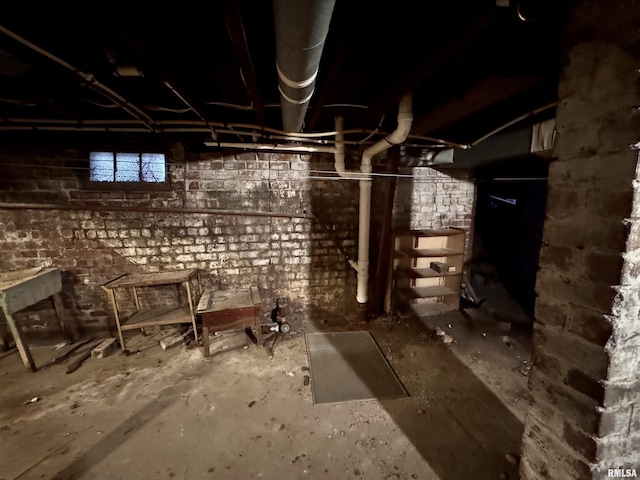 basement featuring brick wall