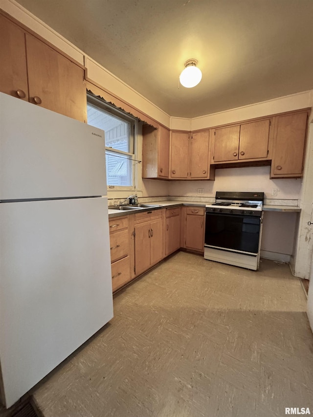 kitchen featuring sink, range with gas cooktop, and white fridge