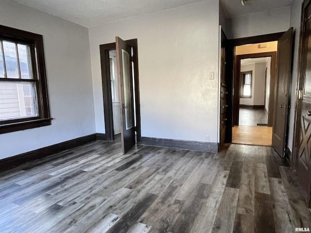 empty room featuring dark wood-type flooring and a wealth of natural light