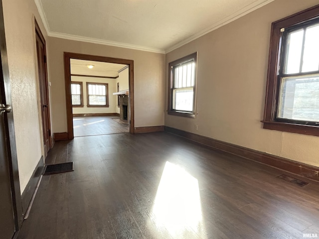 unfurnished room with dark wood-type flooring, ornamental molding, and a fireplace