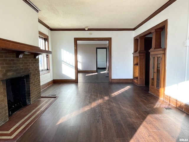 unfurnished living room featuring a brick fireplace, ornamental molding, dark hardwood / wood-style floors, and a textured ceiling