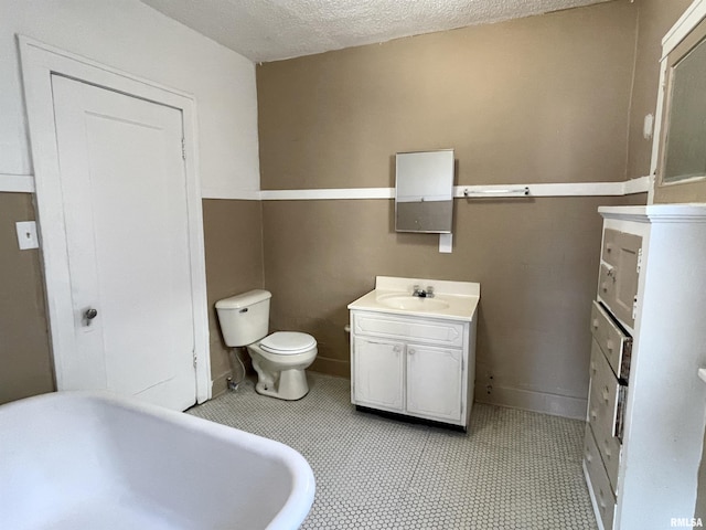 bathroom featuring vanity, a textured ceiling, and toilet