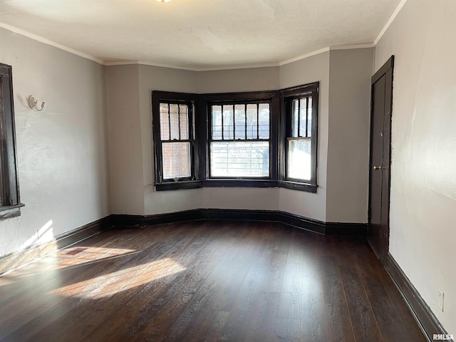 unfurnished room featuring crown molding, a textured ceiling, and dark hardwood / wood-style flooring