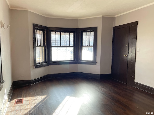 unfurnished room featuring crown molding and dark hardwood / wood-style flooring