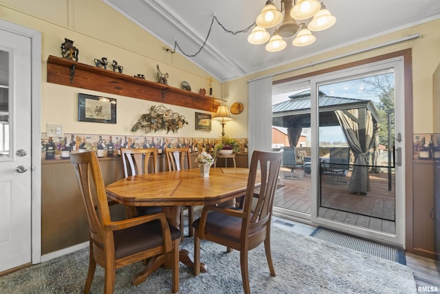 dining space with lofted ceiling and an inviting chandelier