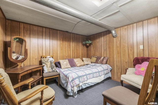 bedroom featuring wood walls and carpet