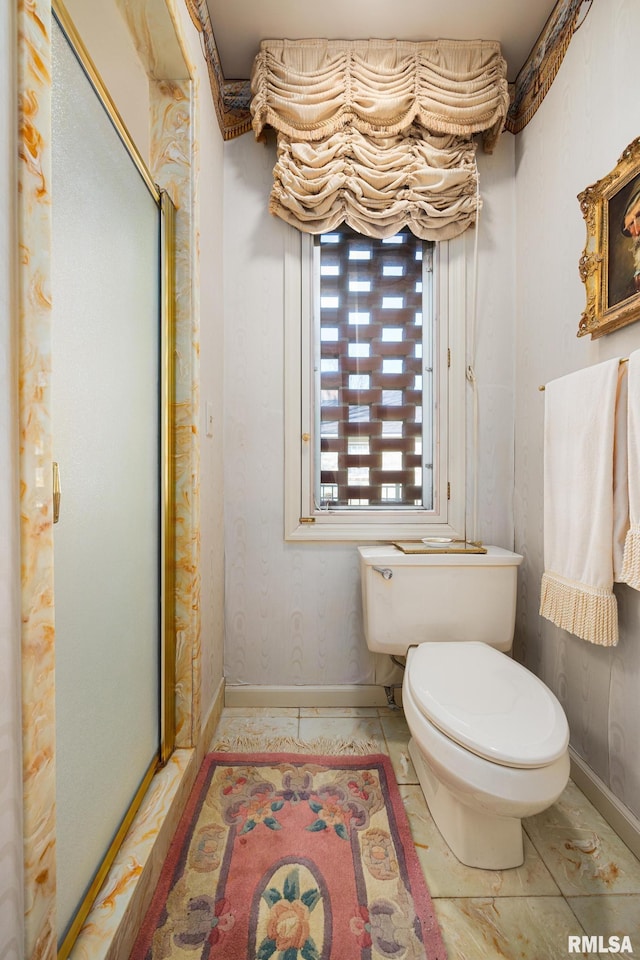 bathroom with a shower with door and toilet