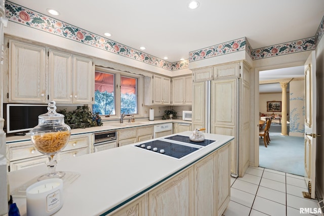 kitchen featuring light tile patterned floors, white appliances, sink, and ornate columns