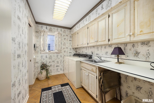 laundry room featuring sink, crown molding, washing machine and dryer, cabinets, and light parquet flooring