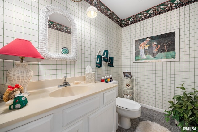 bathroom with tile walls, vanity, and toilet