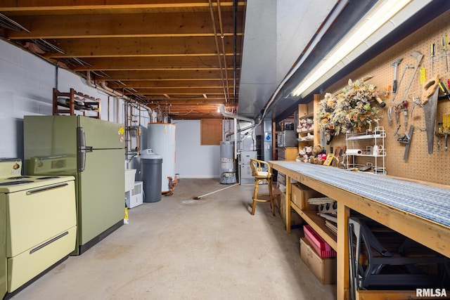 basement featuring heating unit, refrigerator, a workshop area, and gas water heater