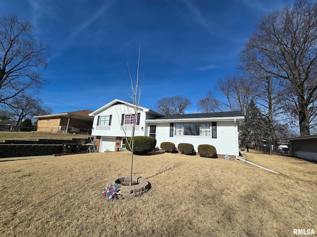 tri-level home featuring a garage and a front lawn