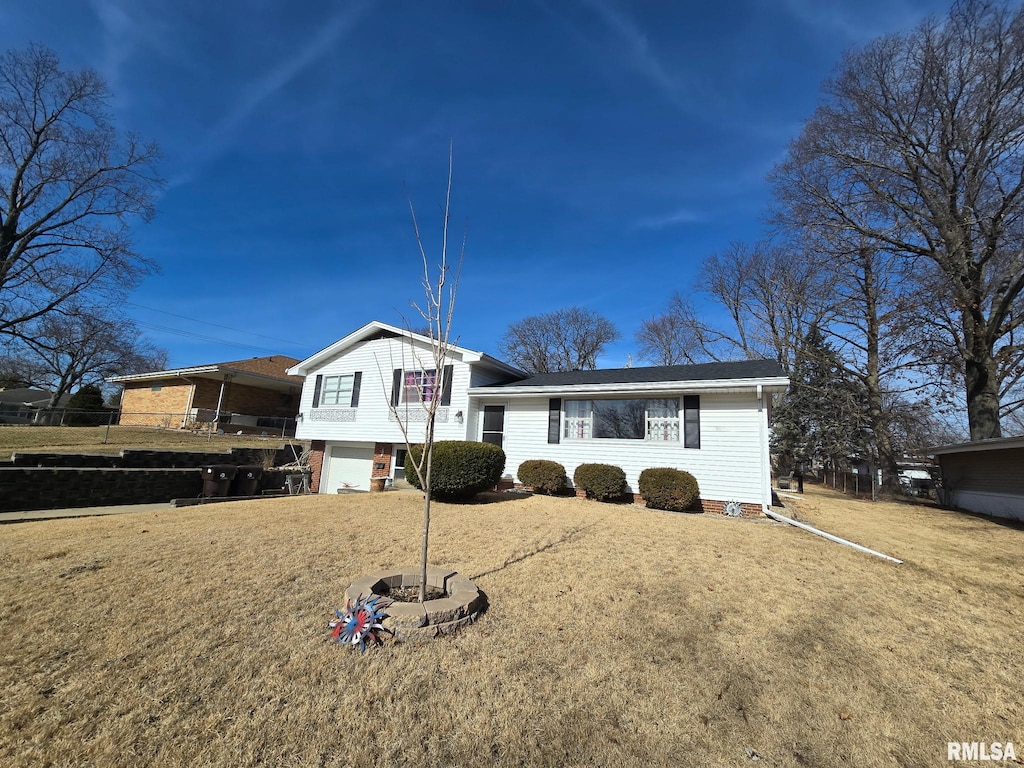 tri-level home with a garage and a front lawn