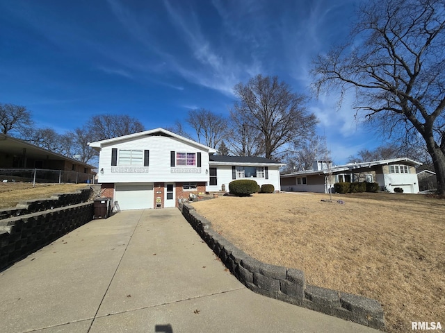 tri-level home with a garage and a front yard