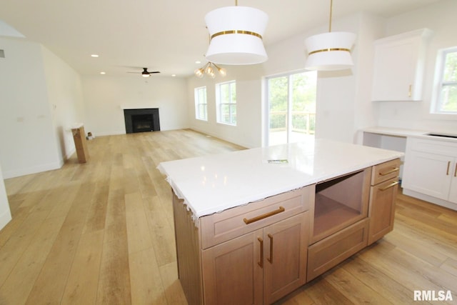 7023 N Water Oak Dr, Edwards, IL 61528 - kitchen with light wood-style floors, a fireplace, a ceiling fan, recessed lighting, and a center island
