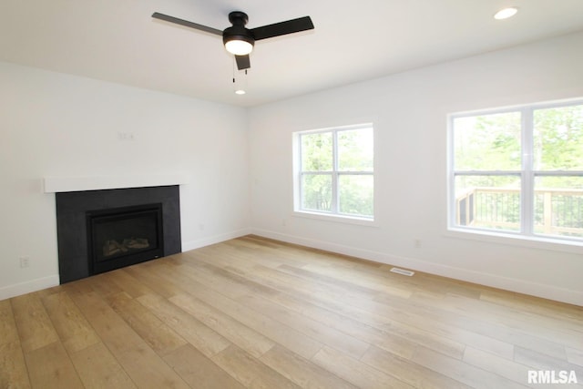 7023 N Water Oak Dr, Edwards, IL 61528 - unfurnished living room featuring light wood finished floors, a glass covered fireplace, baseboards, ceiling fan, and recessed lighting
