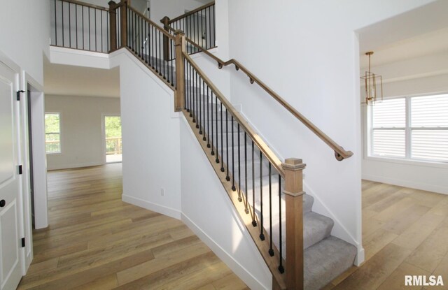 7023 N Water Oak Dr, Edwards, IL 61528 - stairway with wood finished floors, a chandelier, and baseboards