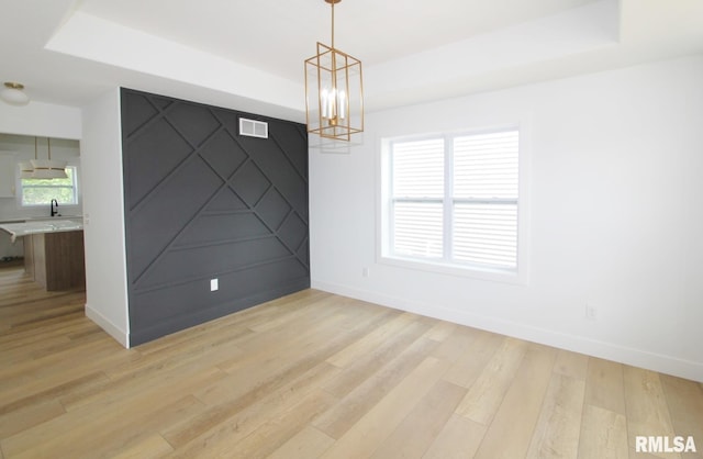 7023 N Water Oak Dr, Edwards, IL 61528 - unfurnished room with a tray ceiling, a chandelier, light wood finished floors, and baseboards