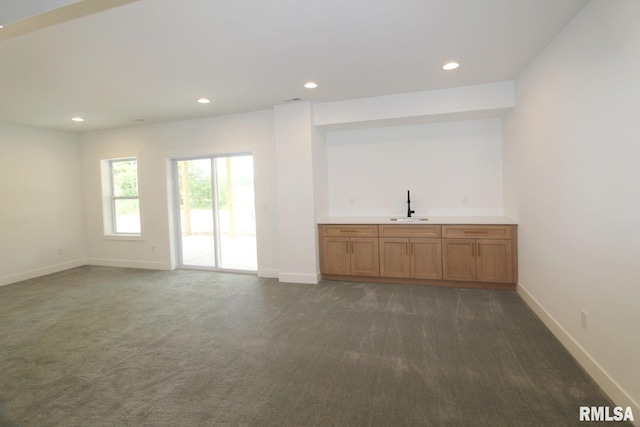 7023 N Water Oak Dr, Edwards, IL 61528 - unfurnished living room featuring dark colored carpet, recessed lighting, baseboards, and bar with sink