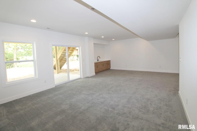 7023 N Water Oak Dr, Edwards, IL 61528 - unfurnished living room featuring carpet flooring, baseboards, recessed lighting, and a sink