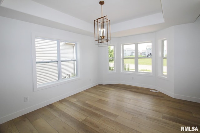 7023 N Water Oak Dr, Edwards, IL 61528 - empty room with a chandelier, baseboards, light wood finished floors, and a raised ceiling