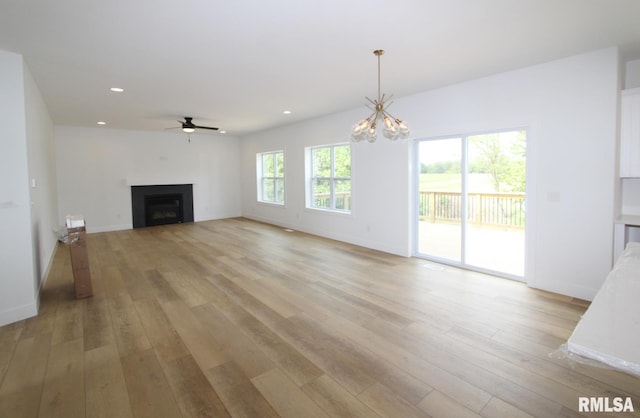 7023 N Water Oak Dr, Edwards, IL 61528 - unfurnished living room with a fireplace, ceiling fan, light wood finished floors, recessed lighting, and a chandelier