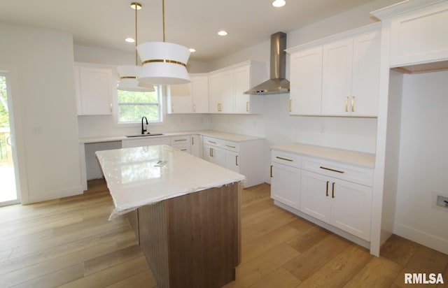 7023 N Water Oak Dr, Edwards, IL 61528 - kitchen with wall chimney range hood, a sink, a kitchen island, light wood-type flooring, and white cabinetry