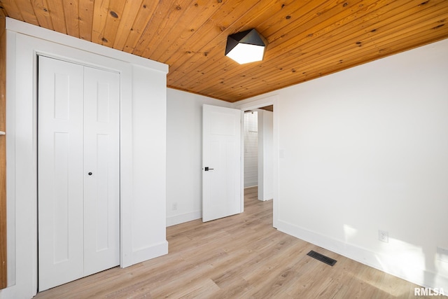 unfurnished bedroom with wood ceiling, a closet, and light wood-type flooring