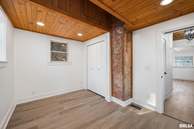 interior space with light hardwood / wood-style flooring, wooden ceiling, and a closet