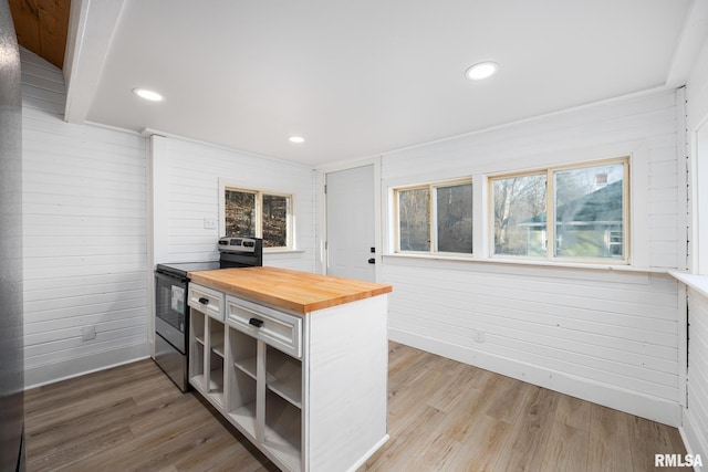 kitchen featuring electric stove, butcher block countertops, and wood-type flooring