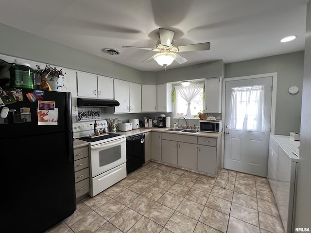 kitchen with sink, black appliances, washer and dryer, ceiling fan, and white cabinets