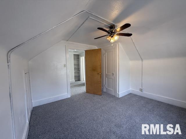 bonus room with vaulted ceiling and carpet flooring