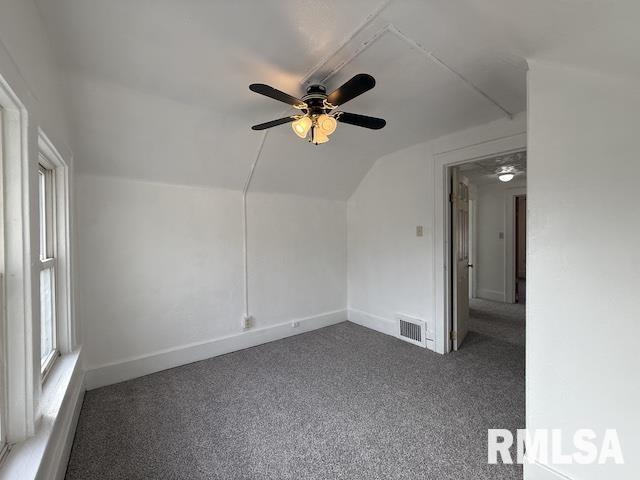 additional living space featuring vaulted ceiling, ceiling fan, and dark carpet