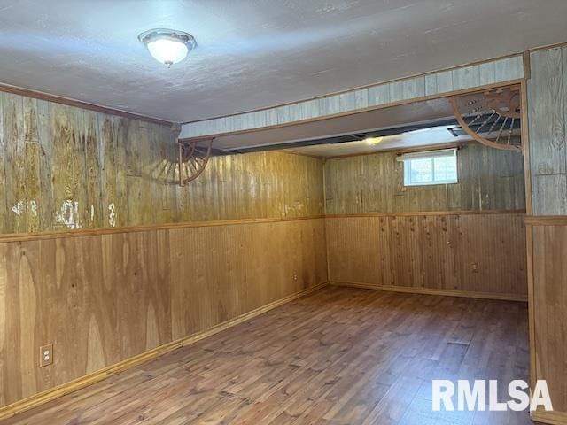 basement with hardwood / wood-style flooring and wood walls