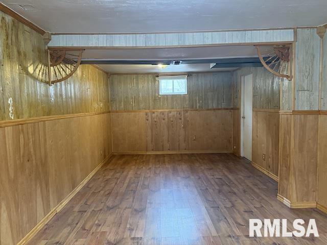 basement featuring wood-type flooring and wooden walls