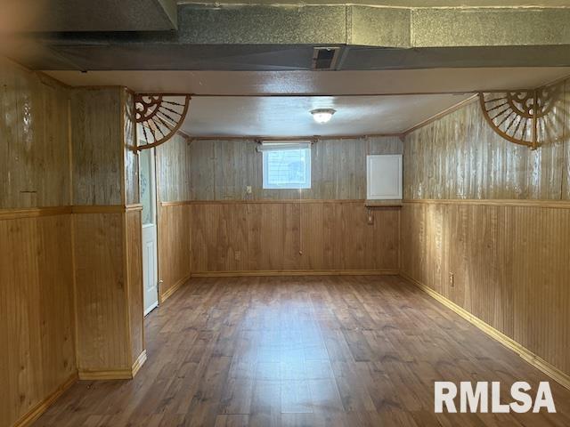 basement with hardwood / wood-style flooring and wooden walls