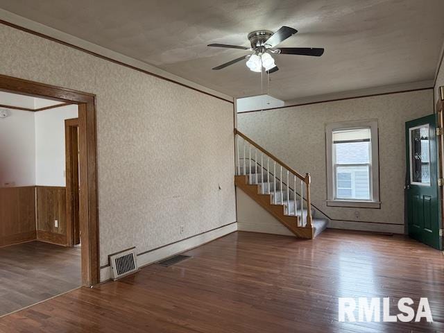 interior space with dark wood-type flooring, ceiling fan, and ornamental molding