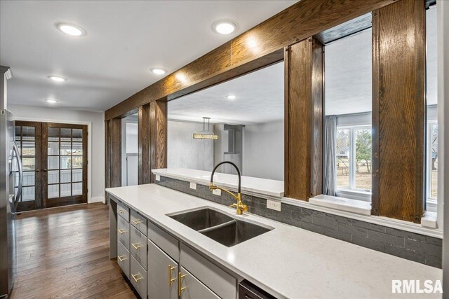 kitchen with sink, hanging light fixtures, beam ceiling, dark hardwood / wood-style floors, and decorative backsplash