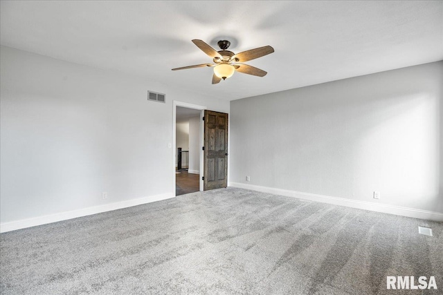 empty room featuring ceiling fan, baseboards, visible vents, and dark carpet