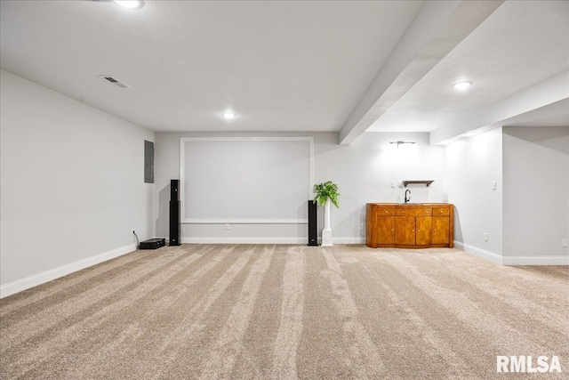 basement featuring sink and light colored carpet