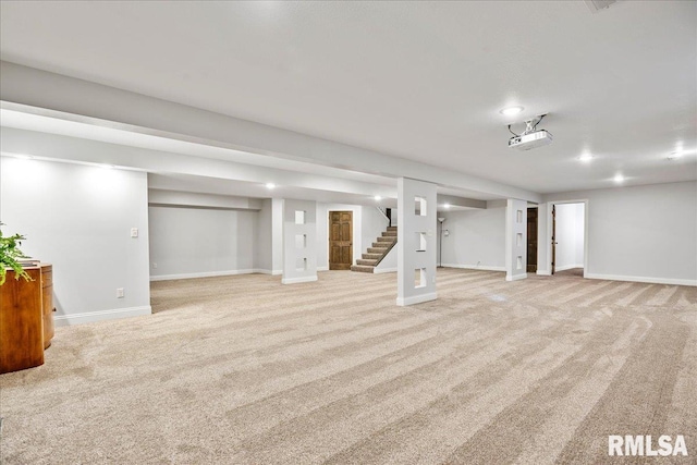 finished below grade area with recessed lighting, light colored carpet, stairway, and baseboards