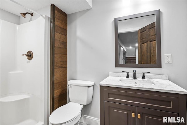 bathroom featuring vanity, toilet, and a shower