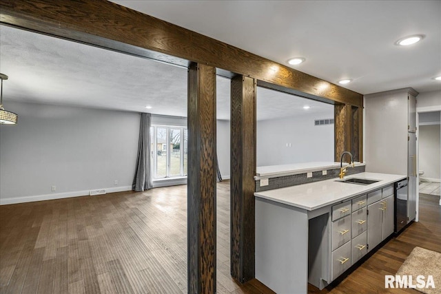 kitchen with dishwashing machine, sink, gray cabinets, dark hardwood / wood-style flooring, and beamed ceiling